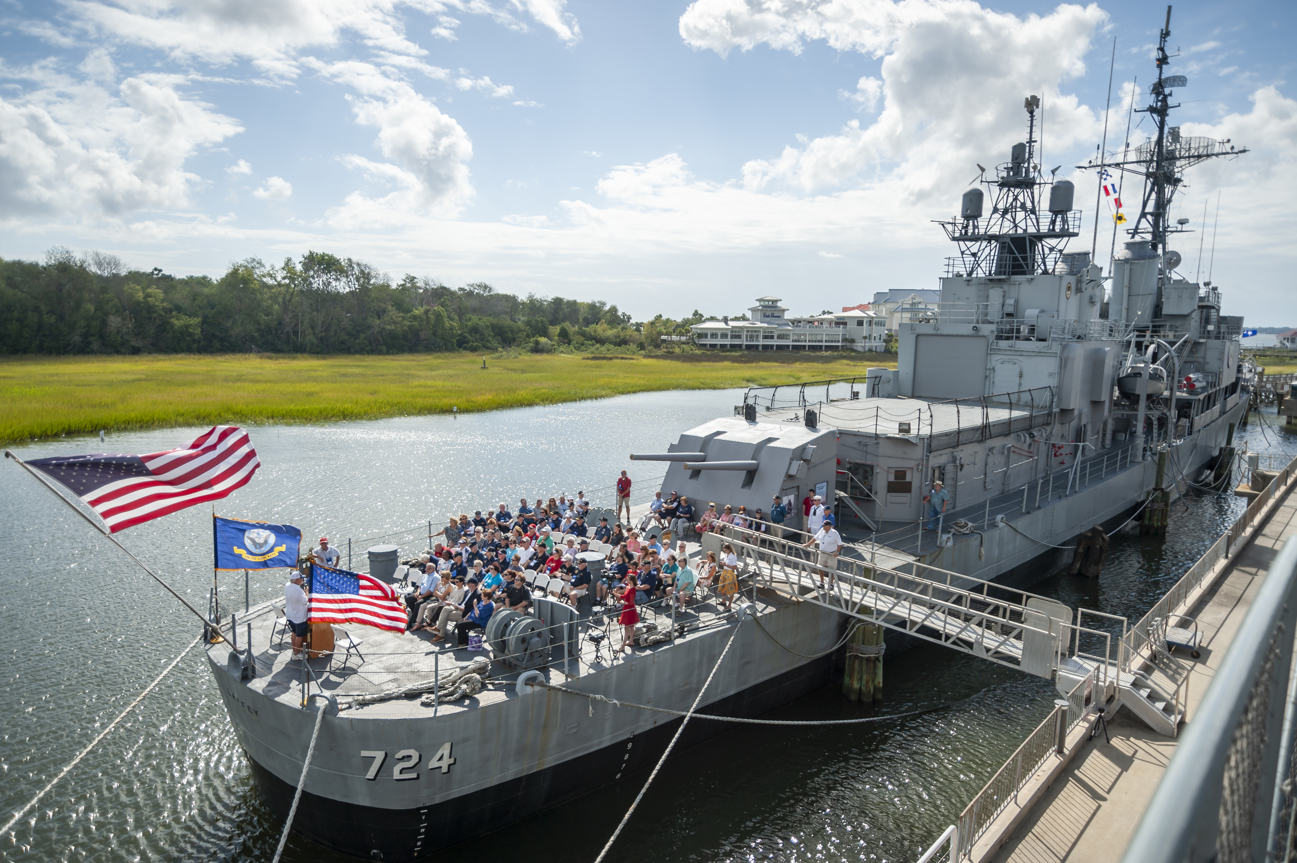 image of a group of people gathered on the bow of the USS Laffey with 2 American flags