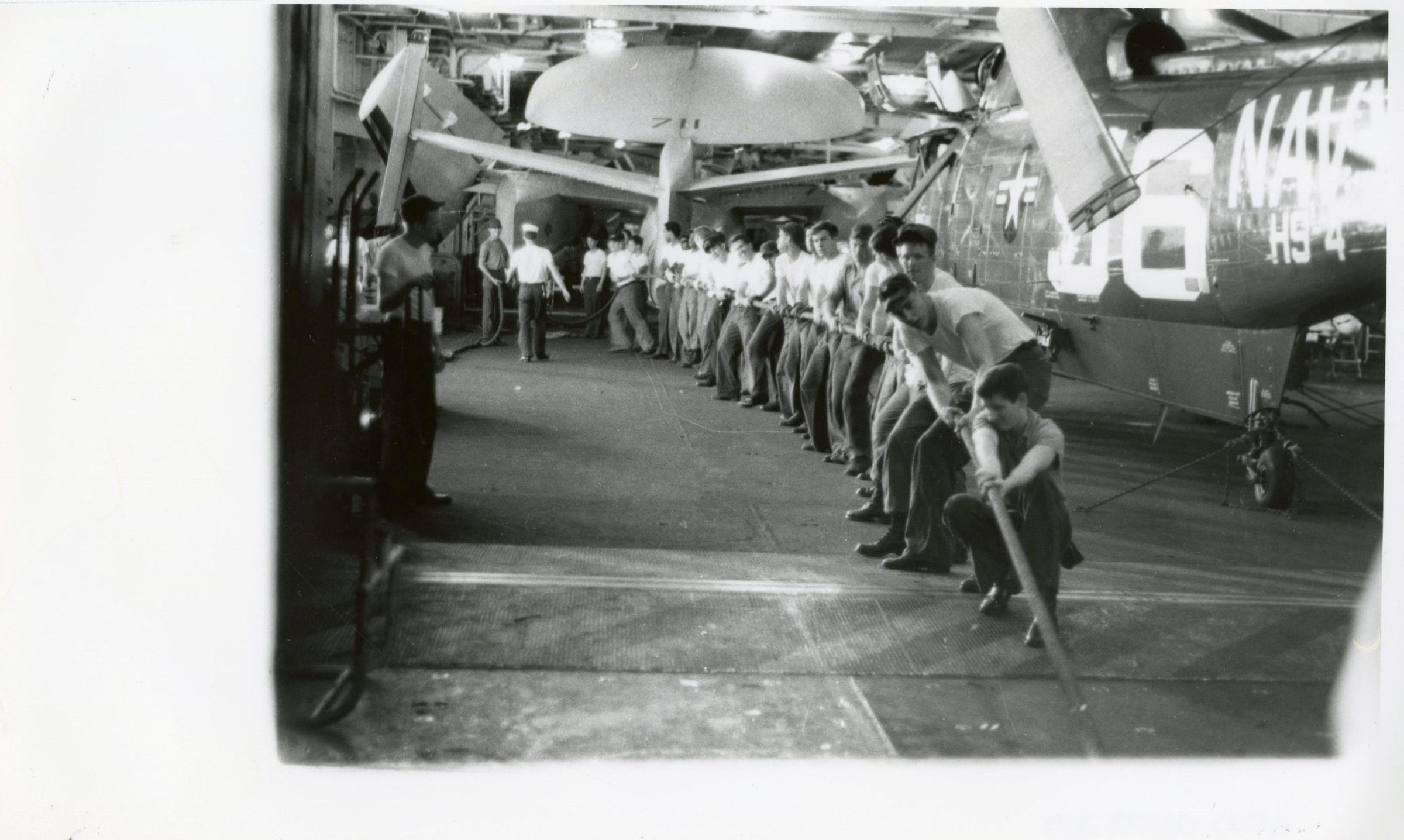 Primary Image of Crewmembers Working in the Hanger Deck