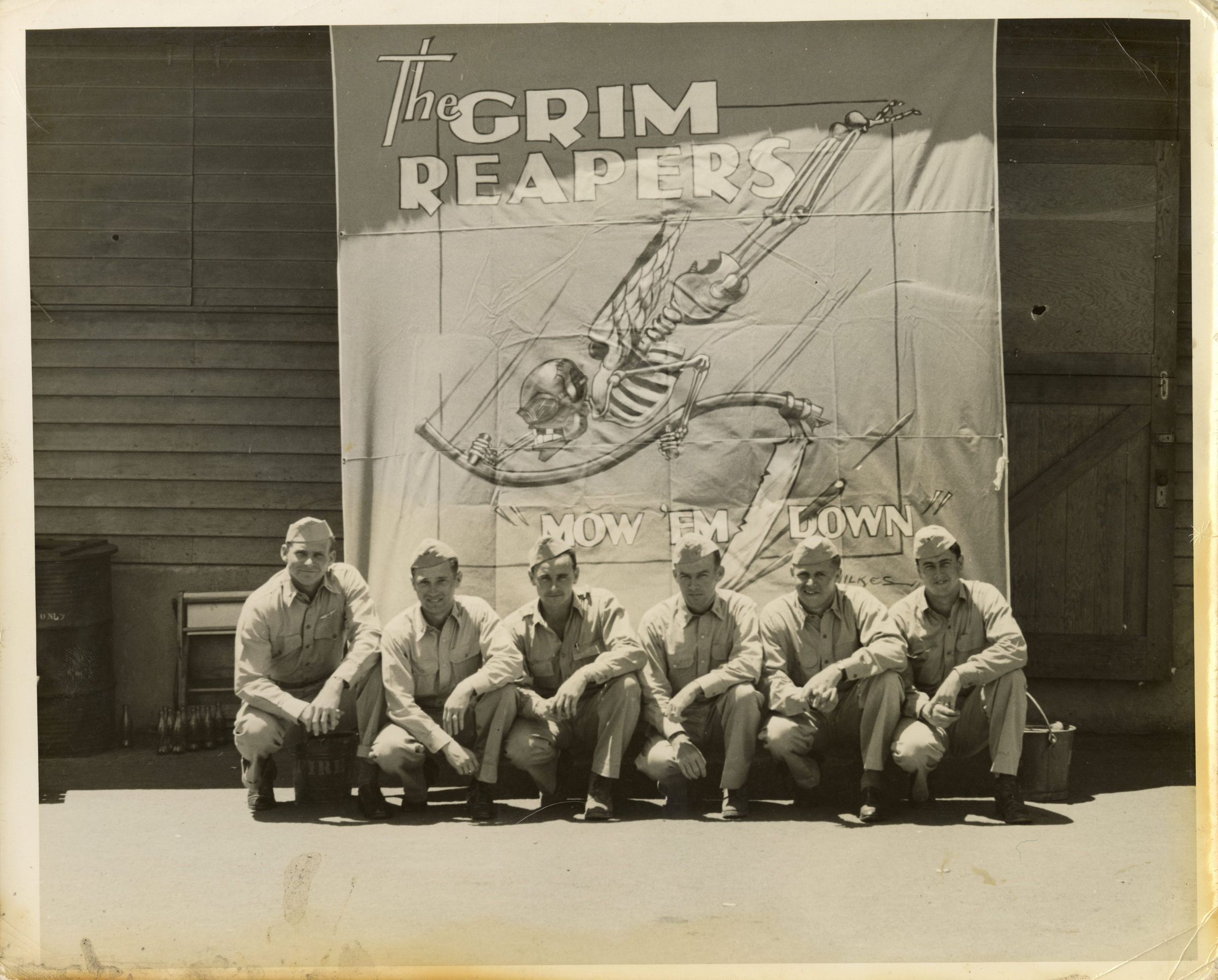 Primary Image of Several Members of Fighting Squadron Ten (VF-10) Sitting in Front of a Grim Reapers Banner