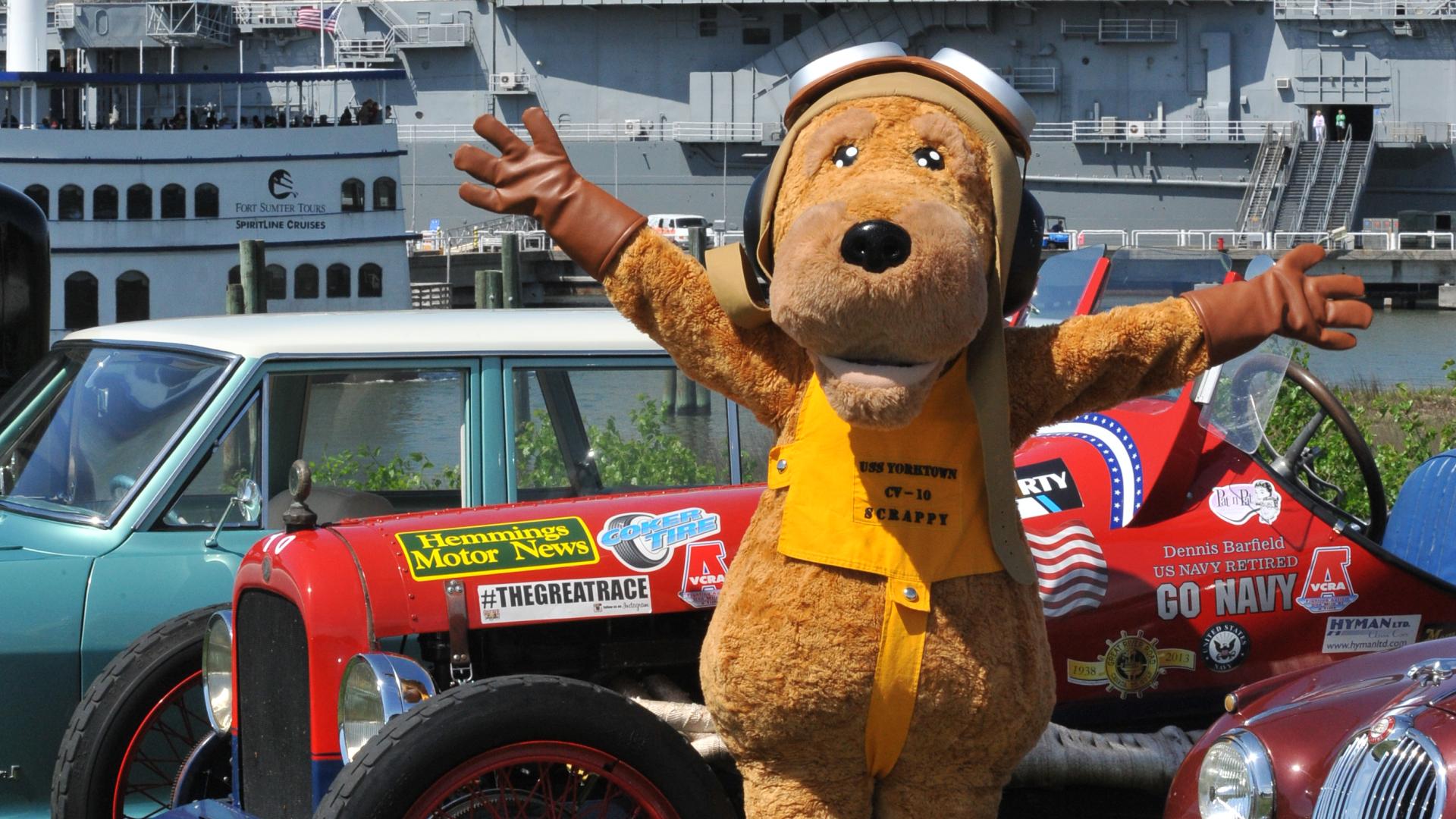 Scrappy, the Patriots Point Naval & Maritime Museum mascot, standing around antique automobiles