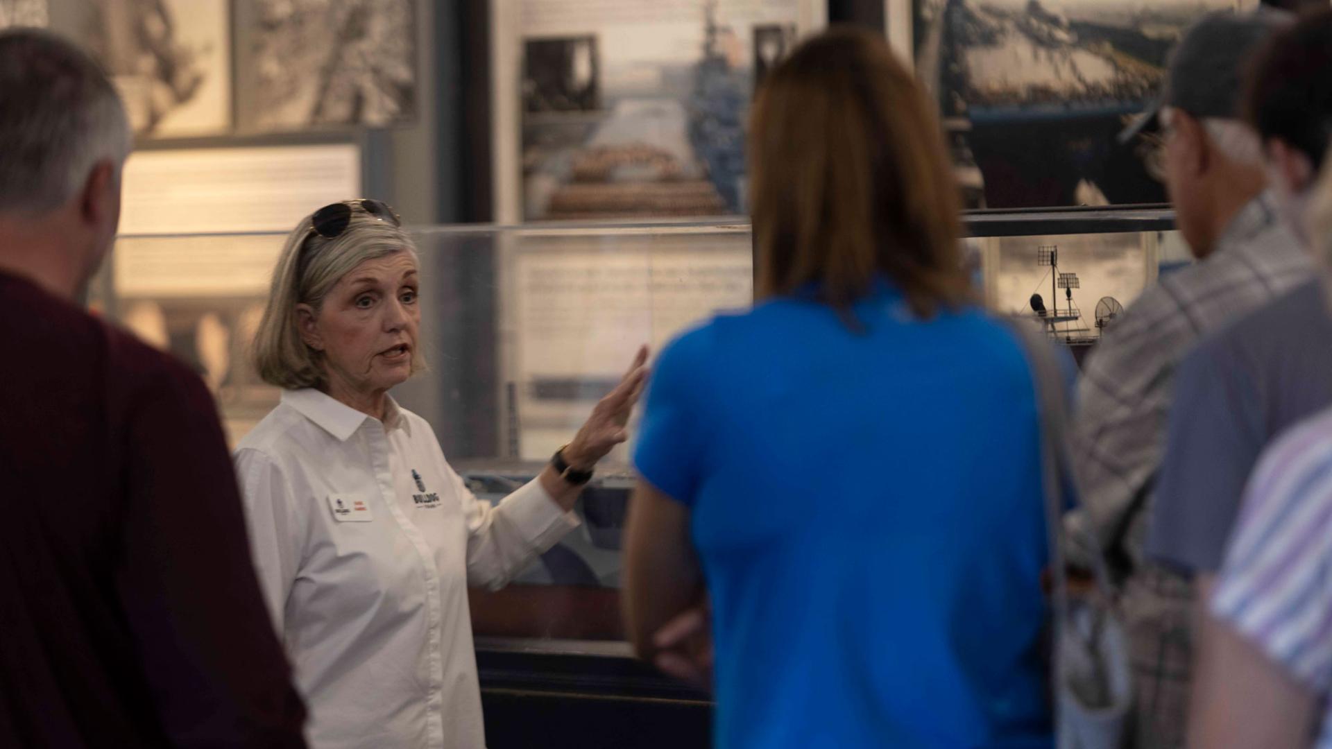 image of a woman giving a tour in an aviation museum
