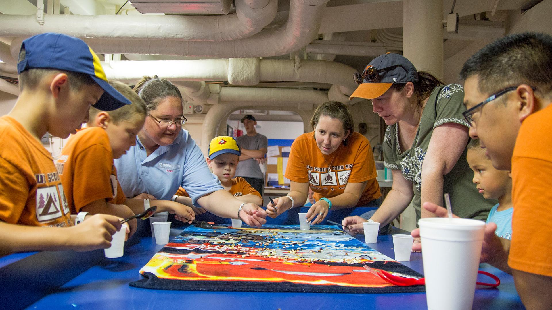 Group of adults and kids stand around a map