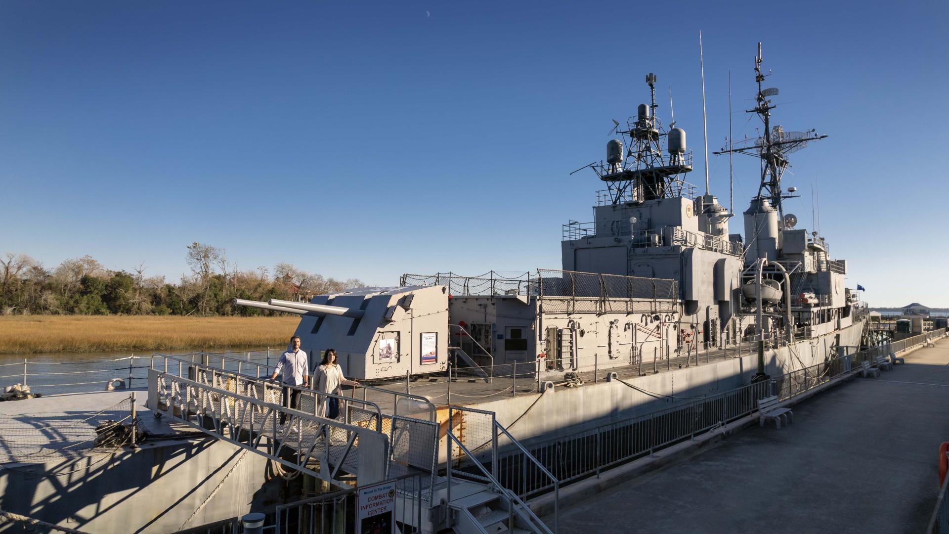 Couple walks on the walkway off of the USS Laffey.