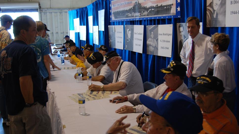 Veterans signing posters at the USS Yorktown CV-10 Association "Meet And Greet" 