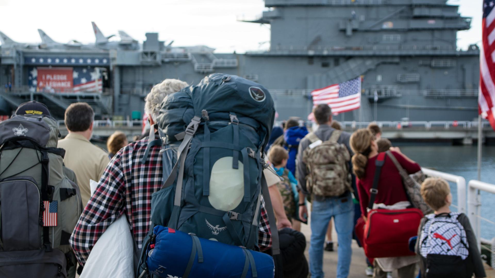 People carrying on backpacks and overnight bags for Operation Overnight