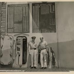 Primary Image of Stephen D. Fitch and Richard L. Montfort in Front of USS Yorktown Score Boards