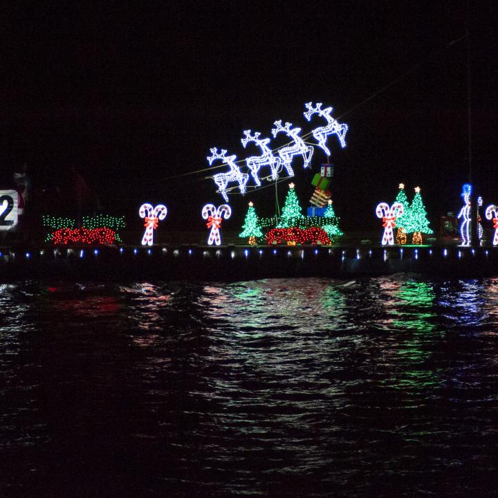 Lights on the Harbor: A Boat Parade Watch Party showing a boat with lit up holiday decorations