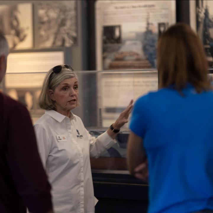 image of a woman giving a tour in an aviation museum