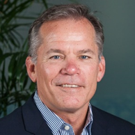 Man with salt and pepper hair wearing a button up shirt and suit coat