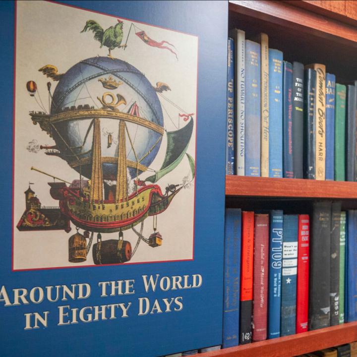 Poster beside a bookcase reads: Around the World in Eighty Days