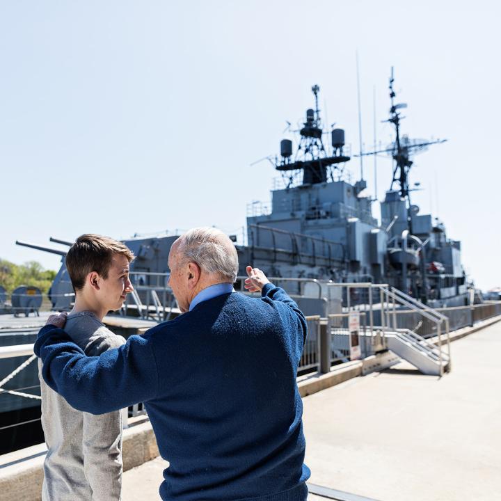 A father and son stand outside the USS Laffey