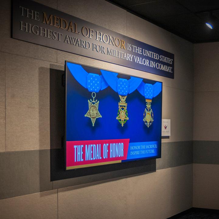 Visitors viewing a screen inside the Medal of Honor Museum