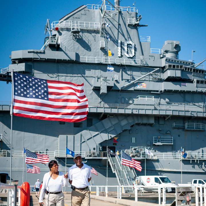 Man and woman walking away from the USS Yorktown