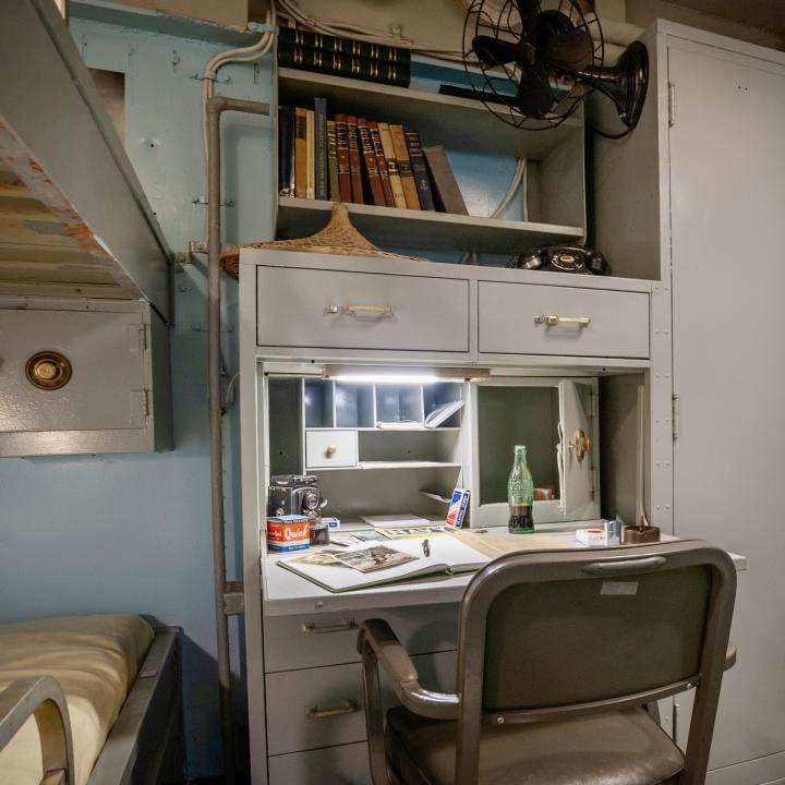 Officer stateroom with bunk, desk, and wardrobe