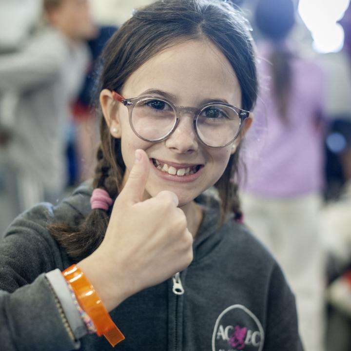 A girl gives a thumbs up showing off her wristband while participating in Operation Overnight.