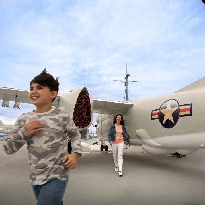 Boy and Woman walk the flight deck.