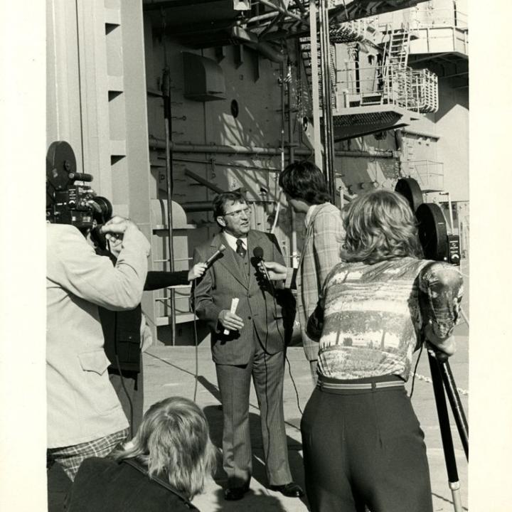 This photograph shows Governor James Edwards being interviewed on the aircraft elevator for opening day ceremonies aboard the USS Yorktown, January 3, 1976.