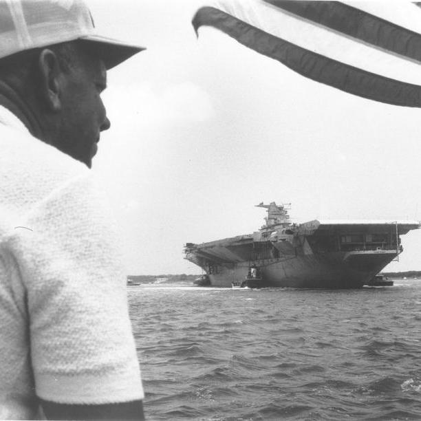 Man watches the USS Yorktown come into the Charleston Harbor.