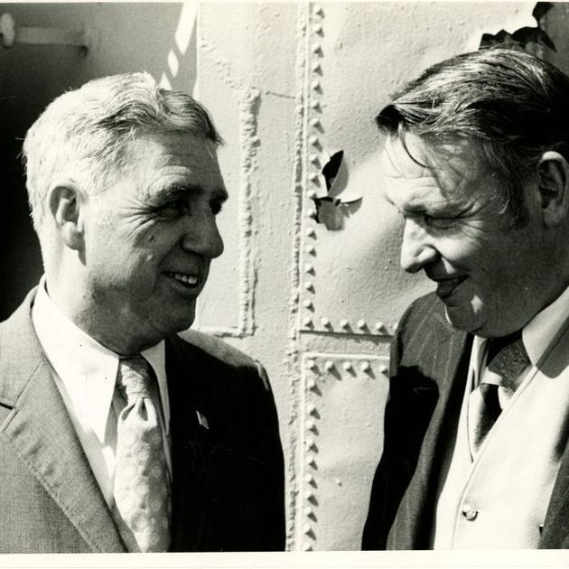 This photograph shows Director Kossler (left) speaking with another man during the opening day ceremonies aboard the USS Yorktown, January 3, 1976.