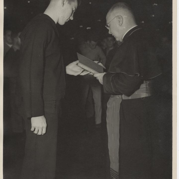 Primary Image of Cardinal Francis Spellman Autographing a Copy of his Book for a Sailor