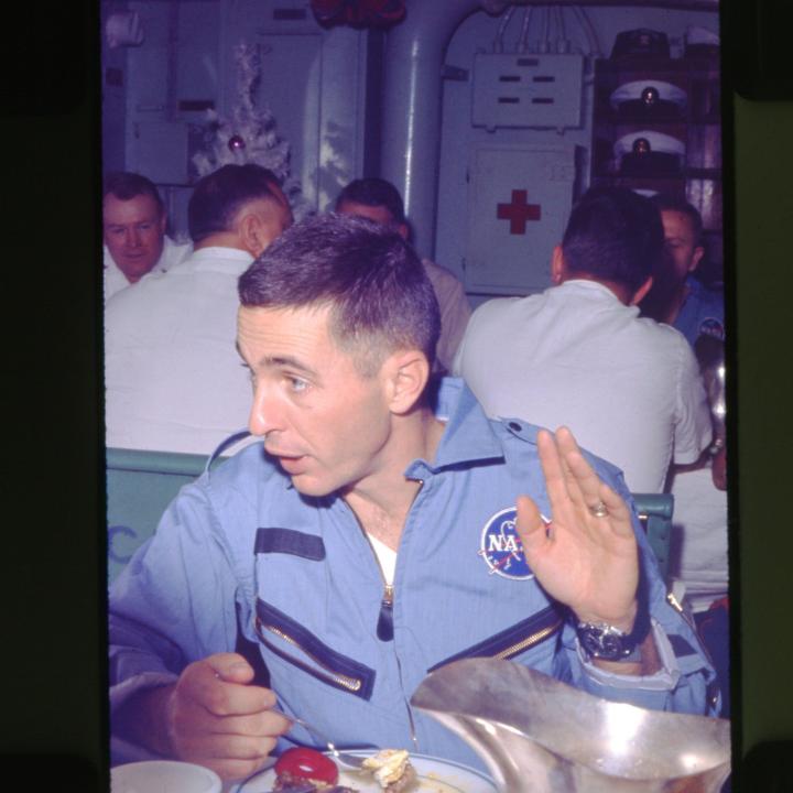 Primary Image of Astronaut William Anders Enjoys a Meal Aboard The USS Yorktown (CVS-10)