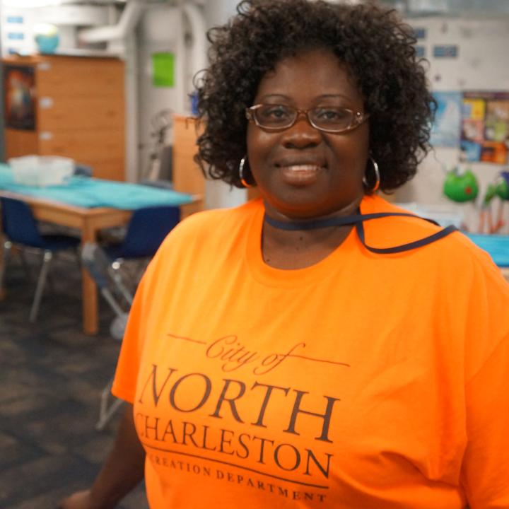Black female with an orange City of North Charleston teeshirt 