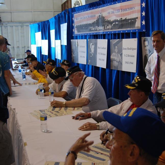 Veterans signing posters at the USS Yorktown CV-10 Association "Meet And Greet" 
