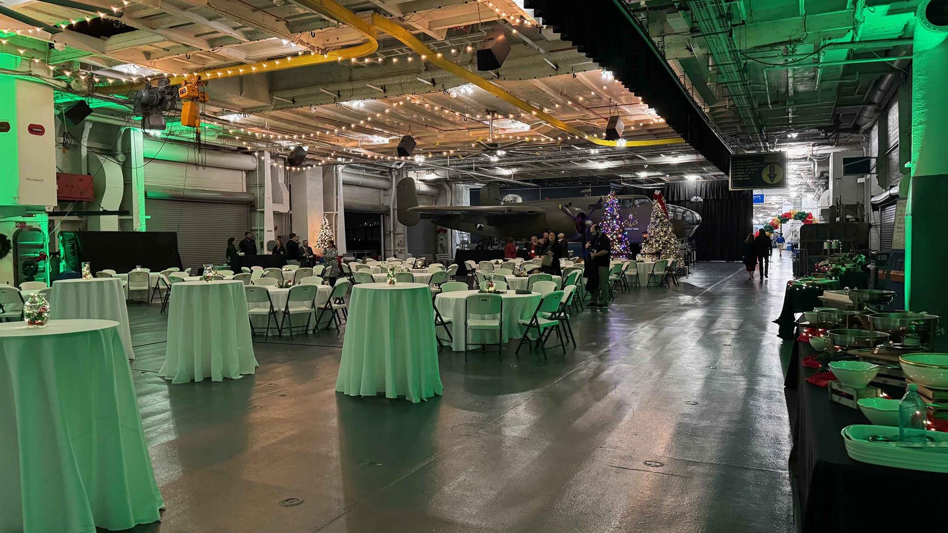 Round tables, standing tables and a buffet set up in the Hangar Bay