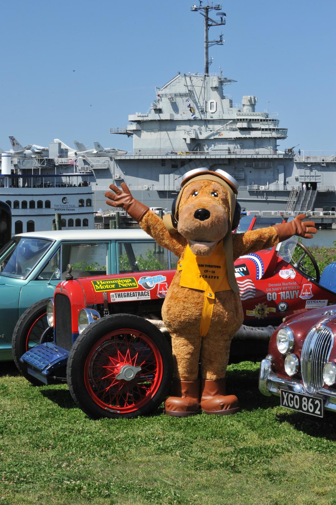 Scrappy, the Patriots Point Naval & Maritime Museum mascot, standing around antique automobiles