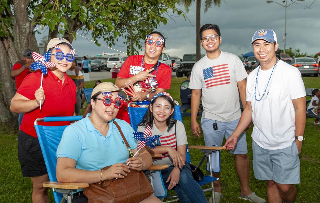Group wearing 4th of July themed sunglasses with pinwheel flags wait for Fireworks to start