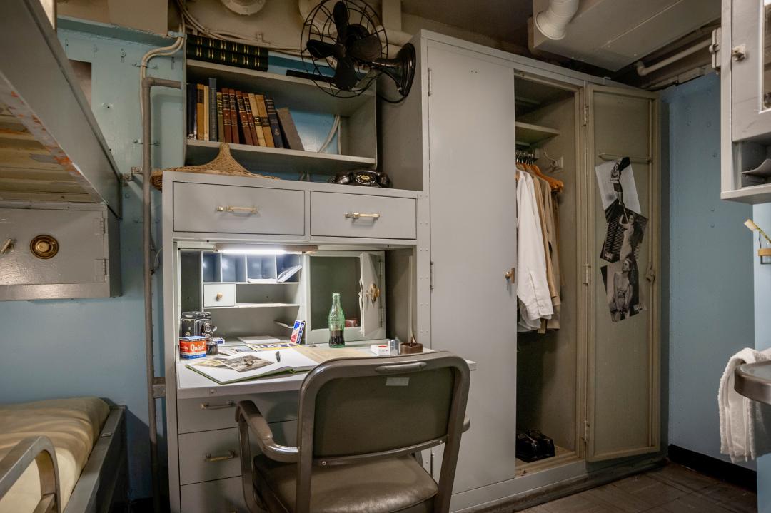 Officer stateroom with bunk, desk, and wardrobe