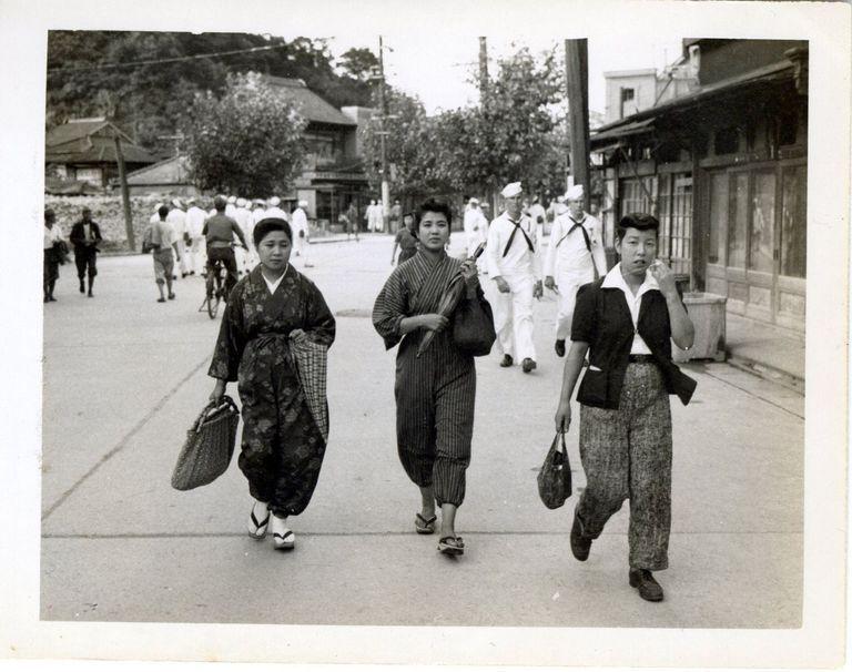 Sailors walk the streets of Japan with civilians.