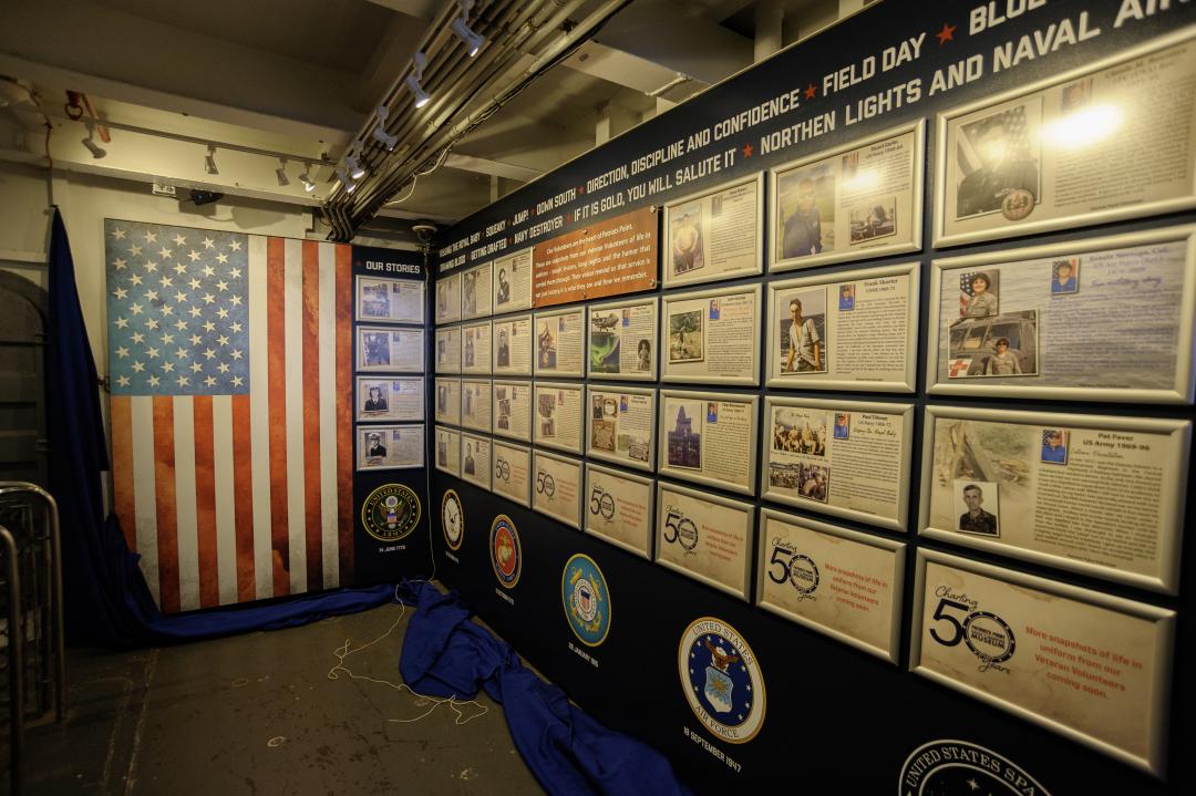 Wall exhibit featuring framed stories by veteran volunteers. 