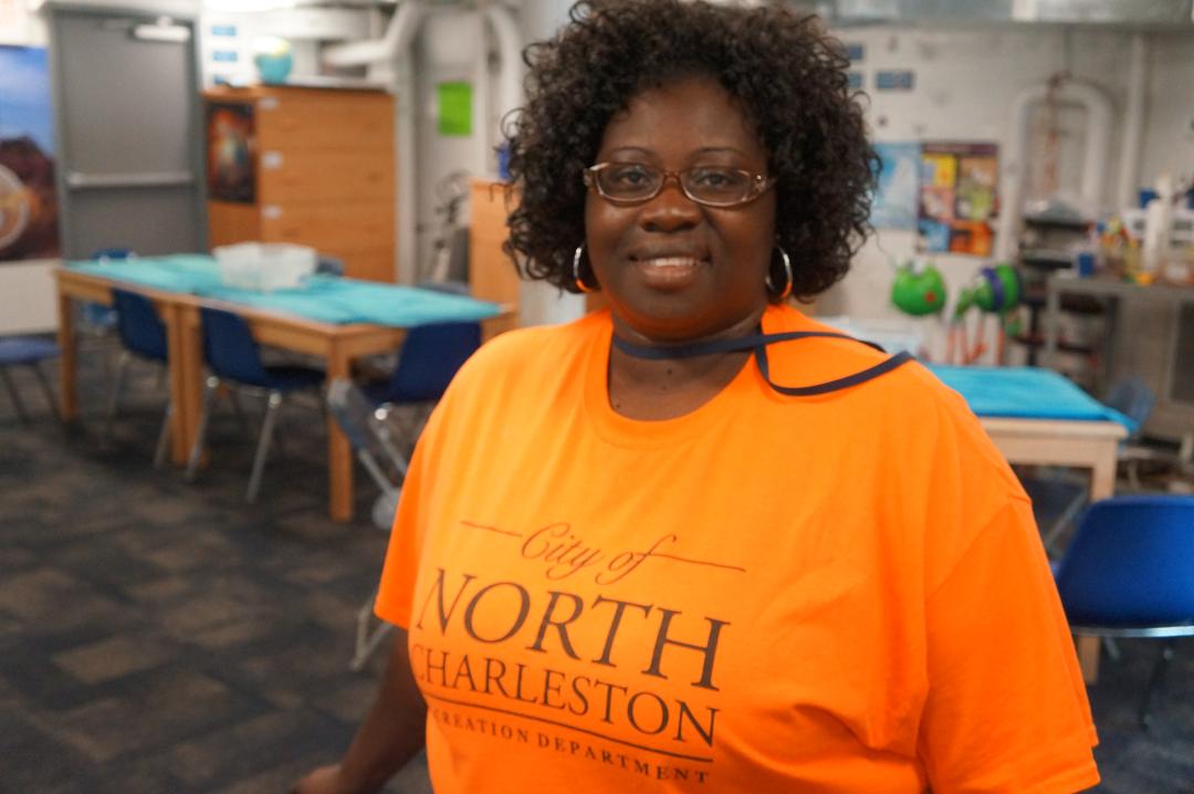 Black female with an orange City of North Charleston teeshirt 