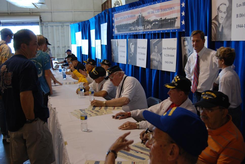Veterans signing posters at the USS Yorktown CV-10 Association "Meet And Greet" 